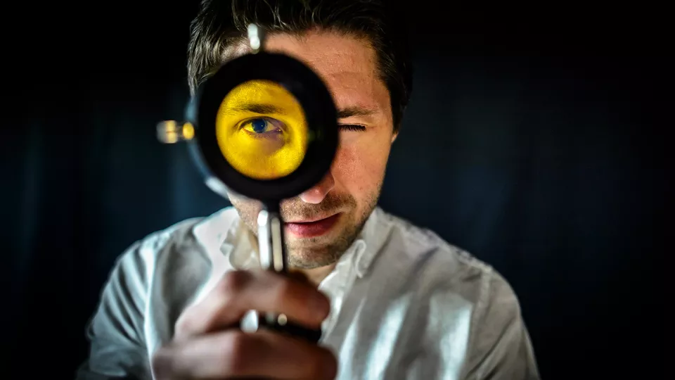 Person med gult filter framför ögat. Foto: Kennet Ruona.